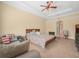 The bedroom features a ceiling fan, a tray ceiling and neutral-colored walls and carpet at 3300 Hawks Ridge Dr, Lakeland, FL 33810