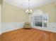 The dining room boasts hardwood floors, a chandelier, wainscoting and a large window with blinds at 3300 Hawks Ridge Dr, Lakeland, FL 33810