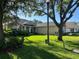 Landscaped front yard with mature trees and lush greenery, enhancing curb appeal of a one-story home at 3300 Hawks Ridge Dr, Lakeland, FL 33810
