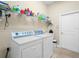 Well-lit laundry room equipped with modern washer and dryer units and ample shelving for storage at 3300 Hawks Ridge Dr, Lakeland, FL 33810