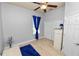 Simple bedroom with wood-look flooring, a closet, and a single window with blue curtains at 1167 Stoney Creek Blvd, Lakeland, FL 33811