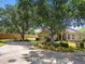 This is a beautiful single-story home featuring lush landscaping and mature trees enhancing its curb appeal at 1167 Stoney Creek Blvd, Lakeland, FL 33811