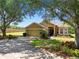Charming home with a well-manicured lawn, mature trees, and a driveway leading to a two-car garage at 1167 Stoney Creek Blvd, Lakeland, FL 33811