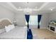 This main bedroom features tray ceilings, a chandelier, and a large window with custom window treatments at 1167 Stoney Creek Blvd, Lakeland, FL 33811