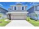 Charming two-story home with a well-manicured lawn, attached two-car garage, and neutral-colored exterior at 2303 Brassie Ct, Winter Haven, FL 33884