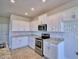 Bright kitchen boasts white cabinets, stainless steel appliances and granite countertops at 2303 Brassie Ct, Winter Haven, FL 33884
