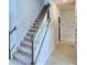 Carpeted staircase with white risers, attractive banister and trim leads to upper level at 2307 Brassie Ct, Winter Haven, FL 33884