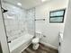 Updated bathroom featuring a tiled shower, modern fixtures, and luxury vinyl plank flooring at 2527 Dons Pl, Lakeland, FL 33801