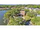 Aerial view of a waterfront home surrounded by lush trees with a circular driveway at 3906 Canyon Lake Pt, Lakeland, FL 33813