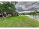 Grassy backyard featuring a screened pool and water view at 3906 Canyon Lake Pt, Lakeland, FL 33813