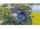 Aerial view of screened pool and spa with lush landscaping and lake view at 3906 Canyon Lake Pt, Lakeland, FL 33813