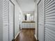 Hallway leading to the bathroom with wood-look flooring and closet space at 4965 Goldenview Ln, Lakeland, FL 33811