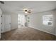 Spacious bedroom with neutral carpet, ceiling fan, and adjacent bathroom and closet at 4965 Goldenview Ln, Lakeland, FL 33811