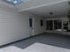 A view of a covered carport showing the white door and partial foliage at 4965 Goldenview Ln, Lakeland, FL 33811