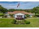 An attractive community clubhouse with manicured lawn, lush landscaping, and an American flag at 4965 Goldenview Ln, Lakeland, FL 33811