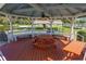 Inviting gazebo interior featuring wooden picnic tables, benches, a ceiling fan, and scenic views of the surrounding landscape at 4965 Goldenview Ln, Lakeland, FL 33811