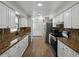 Bright kitchen featuring granite countertops, stainless steel appliances, and wood-look flooring at 4965 Goldenview Ln, Lakeland, FL 33811