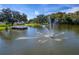 Scenic view of a peaceful pond featuring a fountain and a charming pier at 4965 Goldenview Ln, Lakeland, FL 33811