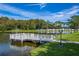A relaxing view of a community pond with a wooden deck and lush greenery at 4965 Goldenview Ln, Lakeland, FL 33811