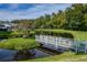 Scenic pond view with a white bridge, mature trees, and lush green surroundings creating a serene and picturesque setting at 4965 Goldenview Ln, Lakeland, FL 33811