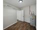 Utility room with water heater, and storage shelves with a white door at 4965 Goldenview Ln, Lakeland, FL 33811