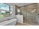 Spa bathroom with freestanding tub, glass shower, and stone-look tile at 505 Shanklin Ave, Bartow, FL 33830