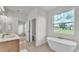 Bright bathroom with soaking tub, dual sinks, and a large window with lawn view at 505 Shanklin Ave, Bartow, FL 33830