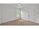 Neutral bedroom featuring a carpeted floor, white walls, and a window overlooking the lawn at 505 Shanklin Ave, Bartow, FL 33830