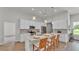 Bright kitchen features white cabinets, quartz countertops, stainless steel appliances, and a center island with bar stool seating at 505 Shanklin Ave, Bartow, FL 33830