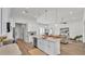 Open concept kitchen featuring quartz counters, stainless appliances, and white cabinets adjoins stylish living area with wood floors at 505 Shanklin Ave, Bartow, FL 33830