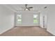 Bright main bedroom with a tray ceiling, carpeted floor, and two bright windows at 505 Shanklin Ave, Bartow, FL 33830