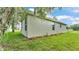 Exterior side of the house with garden area, trimmed shrubs, green grass, and mossy tree at 505 Shanklin Ave, Bartow, FL 33830