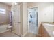 Neutral-toned bathroom with tub/shower combination and a view through to the bedroom at 5612 Vintage View Blvd, Lakeland, FL 33812