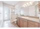 A bright bathroom showcases a shower, granite countertop, wood cabinets, and decorative lighting at 5612 Vintage View Blvd, Lakeland, FL 33812