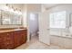 Bathroom featuring a soaking tub, tiled floor, and a wood vanity with a framed mirror at 5612 Vintage View Blvd, Lakeland, FL 33812