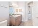 Bright bathroom featuring a granite countertop, wood cabinets, and decorative sconce lighting at 5612 Vintage View Blvd, Lakeland, FL 33812