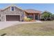 Beautiful single-story home boasts a stone facade, brown siding, well-manicured lawn, and a two-car garage at 5612 Vintage View Blvd, Lakeland, FL 33812
