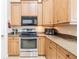 Bright kitchen featuring stainless steel appliances, granite countertops, and natural wood cabinets with plenty of storage space at 5612 Vintage View Blvd, Lakeland, FL 33812