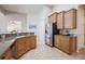 Kitchen with granite countertops, stainless steel refrigerator, natural wood cabinets and tile flooring at 5612 Vintage View Blvd, Lakeland, FL 33812