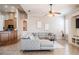 Bright and airy living room with a gray sectional sofa, ceiling fan, and an open layout connecting to the kitchen at 5612 Vintage View Blvd, Lakeland, FL 33812