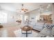 Living room featuring a gray sectional sofa, ceiling fan, and a view to the kitchen at 5612 Vintage View Blvd, Lakeland, FL 33812