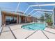 A clear, screened-in pool, is surrounded by concrete and a comfortable seating area on a sunny day at 5612 Vintage View Blvd, Lakeland, FL 33812