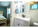 Charming bathroom with a white vanity, a decorative mirror, and a glimpse into the bedroom at 610 Cottage Ln, Lakeland, FL 33803
