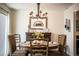 Cozy dining room with a round table, wicker chairs, rustic chandelier, and a decorative sideboard with art at 610 Cottage Ln, Lakeland, FL 33803