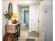 Inviting hallway featuring neutral tones, tile flooring, and a decorative console table with plant and a view to bathroom at 610 Cottage Ln, Lakeland, FL 33803