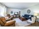 Spacious living room with recliners, a sofa, a wooden coffee table, and large windows offering natural light at 610 Cottage Ln, Lakeland, FL 33803