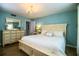 Serene main bedroom showcasing a white bed, a dresser, a chandelier, and light blue walls at 610 Cottage Ln, Lakeland, FL 33803