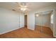 Bedroom with laminate flooring, ceiling fan, closet with mirrored doors, and a white door at 6315 Conductor Ct, Lakeland, FL 33813
