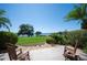 Tranquil backyard view with rocking chairs facing a serene lake, lush greenery, and palm trees at 71 Sunset View Dr # 71, Winter Haven, FL 33884