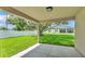 Covered back patio, backyard with large lawn and white fence at 803 Allison Place, Bartow, FL 33830